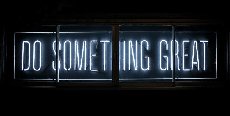 Neon sign on black background with "Do Something Great" legend